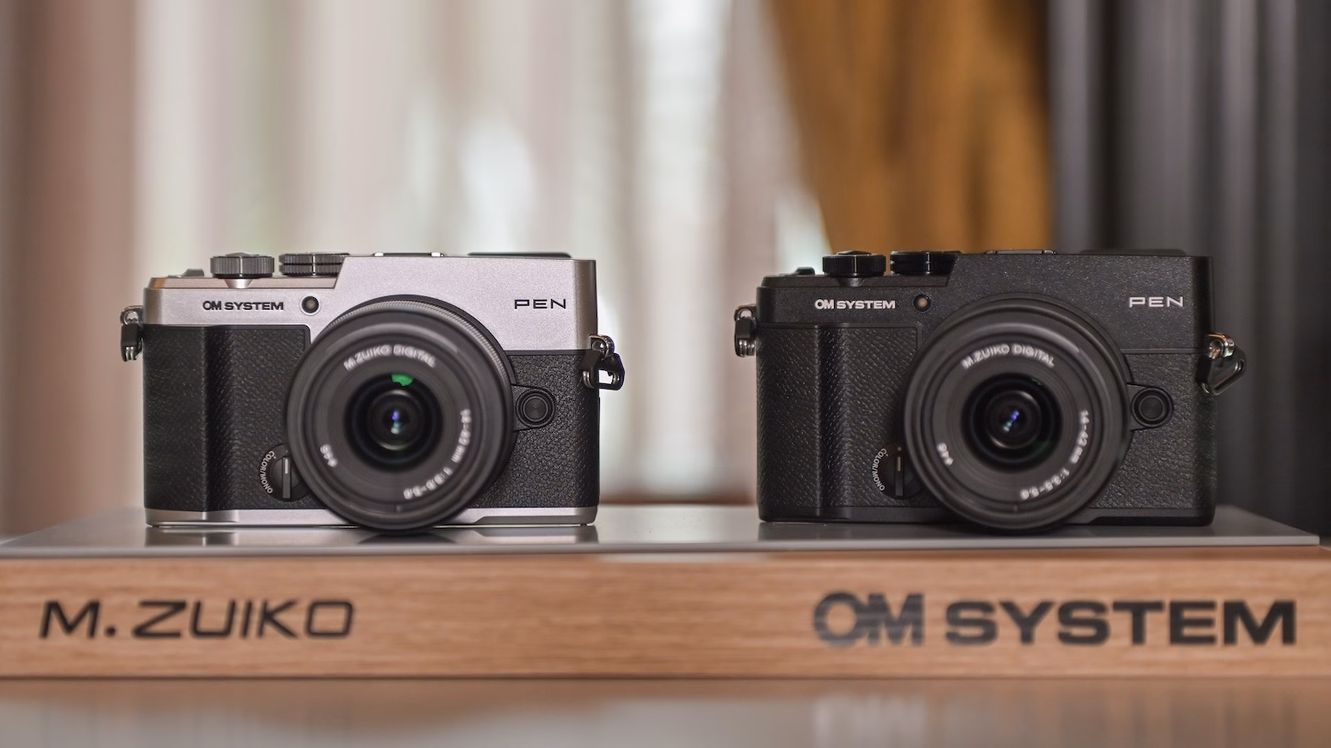 OM SYSTEM PEN สีเงินและสีดำวางคู่กัน
