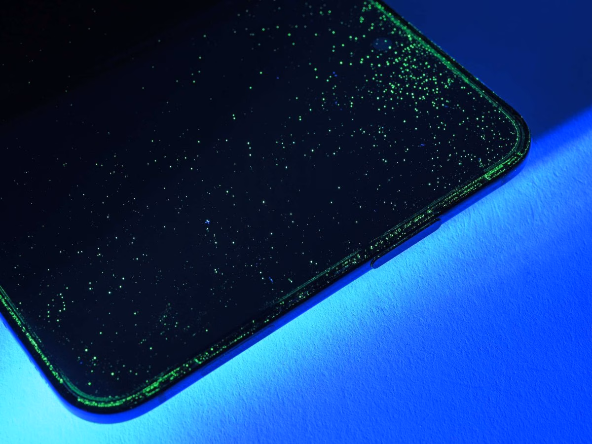 ผงเรืองแสงเกาะรอบขอบจอด้านในของ iPhone Duo หลังการทดสอบฝุ่นของ iFixit
