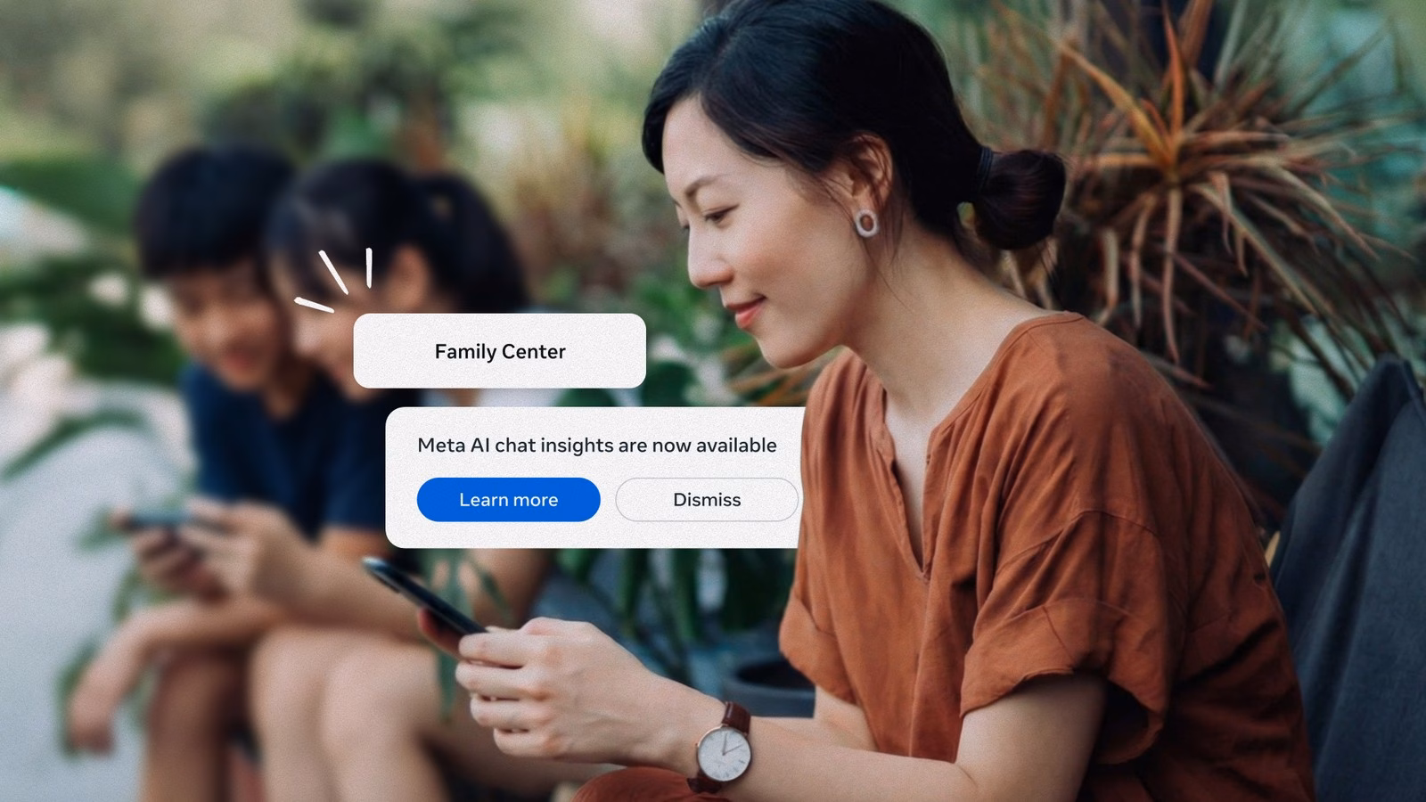 แม่ดูมือถือที่มีการแจ้งเตือน Family Center ว่าข้อมูลเชิงลึกการแชต Meta AI พร้อมใช้งาน ขณะลูกวัยรุ่นนั่งเล่นมือถืออยู่ด้านหลัง