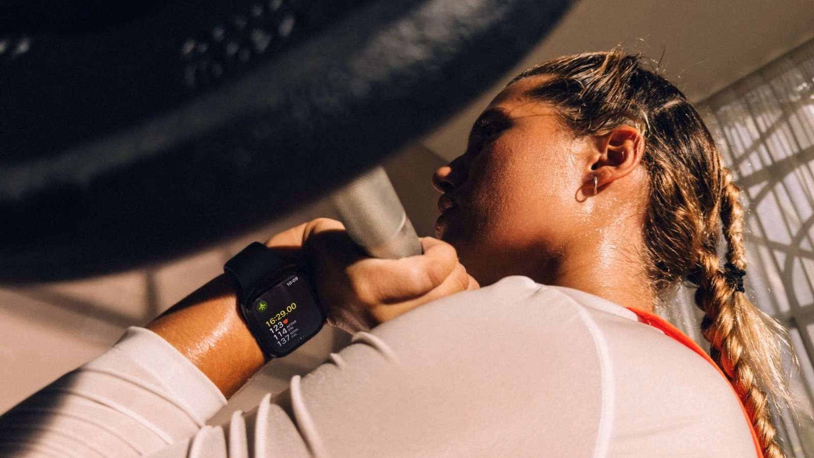 ผู้หญิงใส่ Apple Watch Series 12 ระหว่างเล่นเวทเทรนนิ่ง