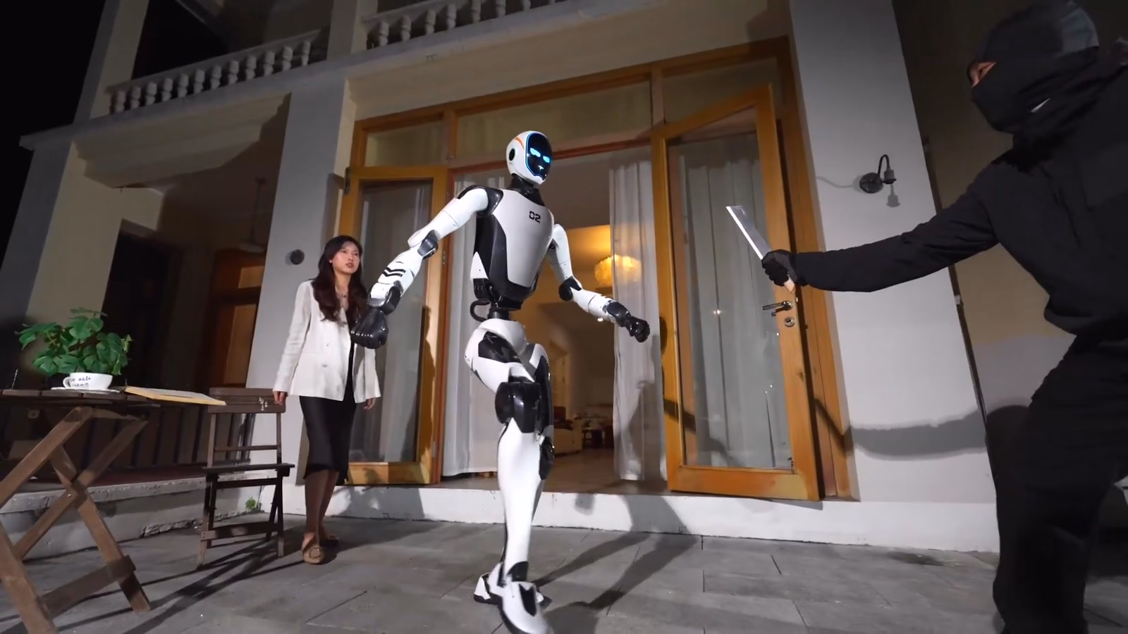 Unitree H2-X ยืนขวางคนร้ายถือมีดในฉากสาธิตงานบอดี้การ์ด
